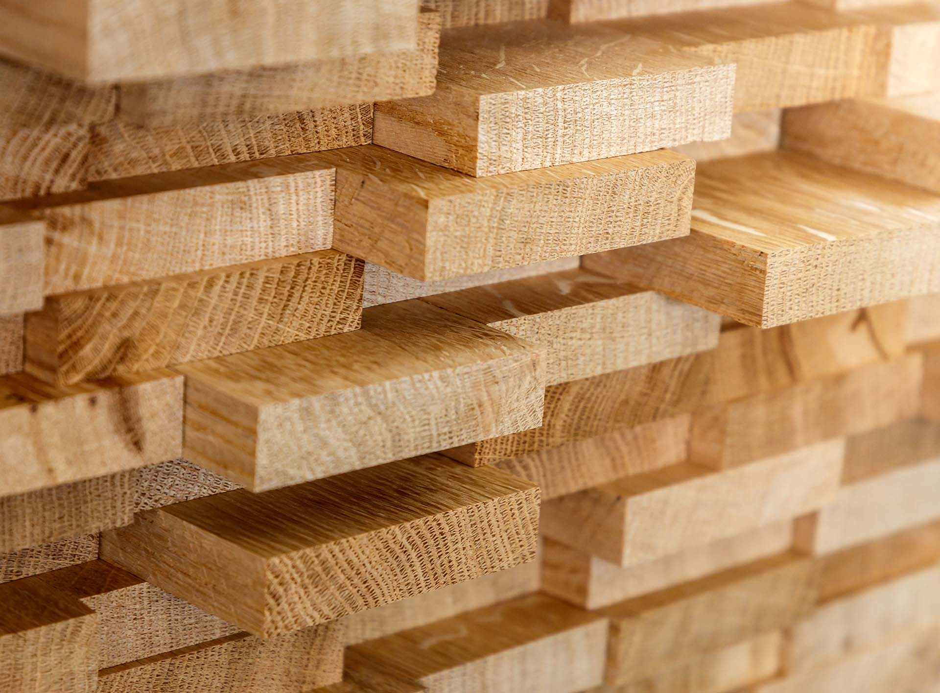 Stapel von geschnittenem, natürlichem Holz im Detail, zeigt Textur und Maserung für Qualitätsbaustoffe.